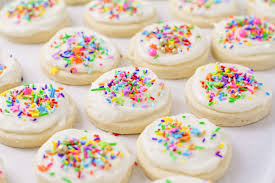 Image of delicious sugar cookies, decorated with frosting and colorful sprinkles on top.